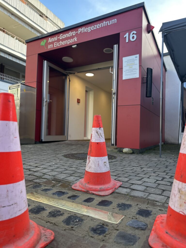 Stolperschwelle mit Blick auf den Eingang des Anni-Gondro-Pflegezentrums
